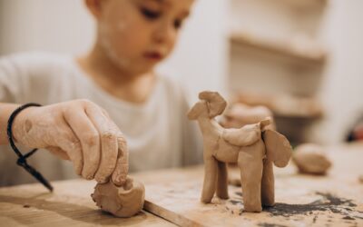 Cute boy forming toys from clay